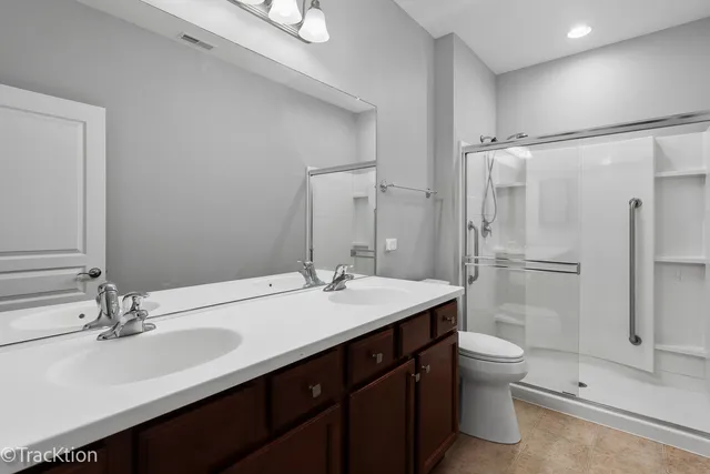 a bathroom with a double vanity sink toilet and shower