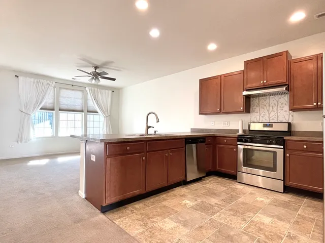 a kitchen with stainless steel appliances granite countertop a sink stove and cabinets