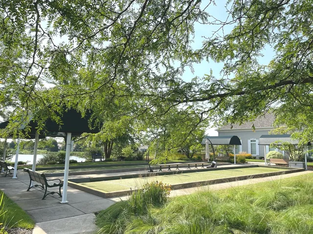 a view of swimming pool with outdoor seating and trees in the background