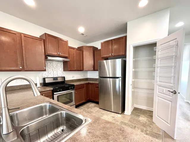 a kitchen with a refrigerator sink and cabinets