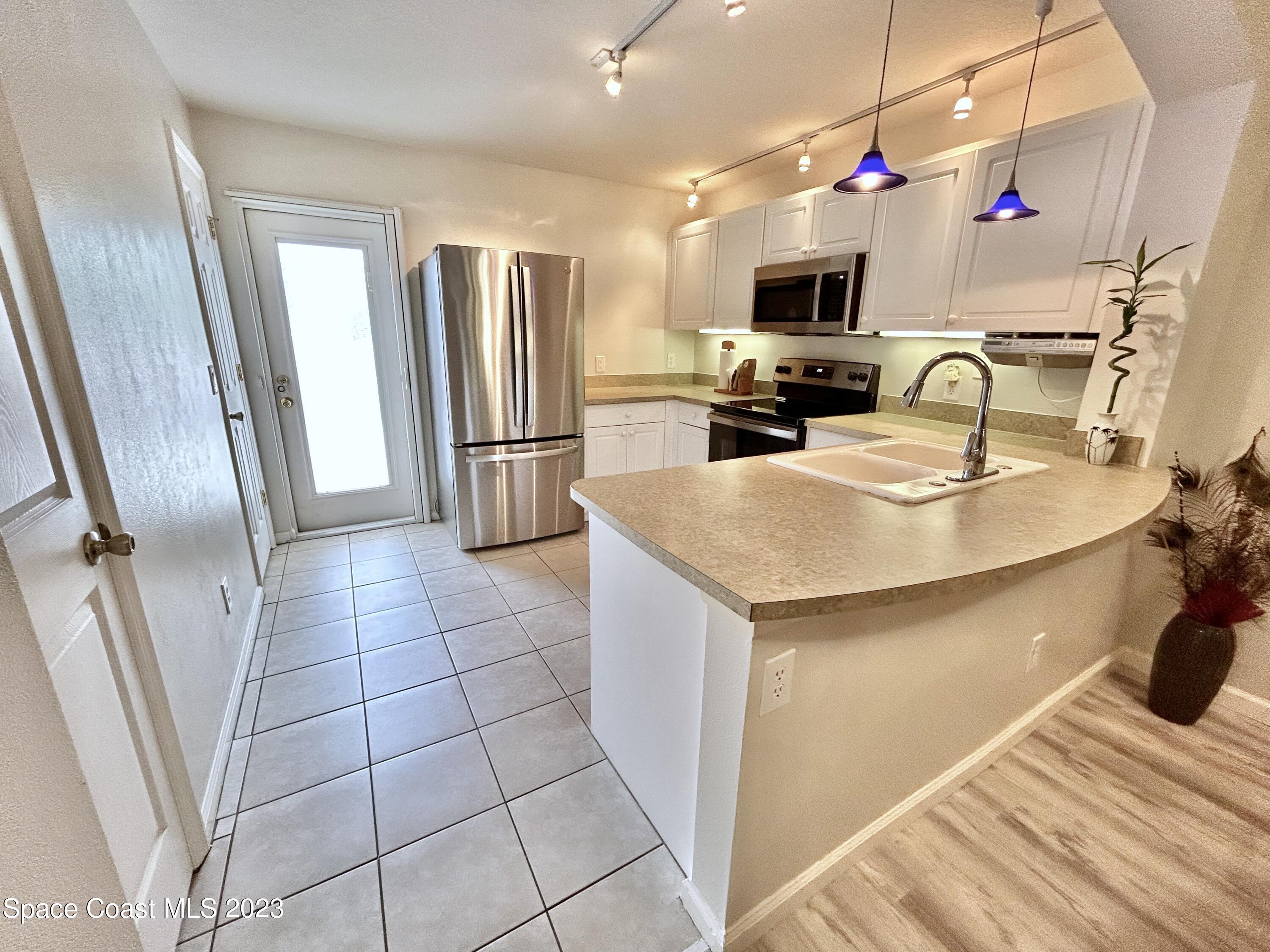 1160 Luminary Circle, Unit 105 Melbourne, FL 32901 - Photo 13 of 35 a kitchen with stainless steel appliances a refrigerator a sink a stove top oven a counter space and cabinets