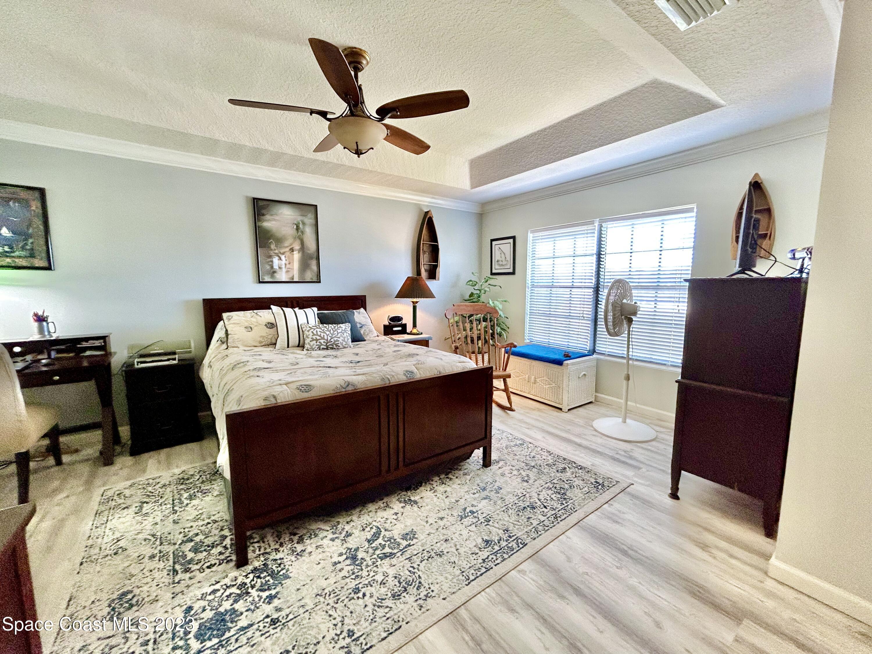 1160 Luminary Circle, Unit 105 Melbourne, FL 32901 - Photo 20 of 35 a living room with a couch bookshelf and a wooden floor