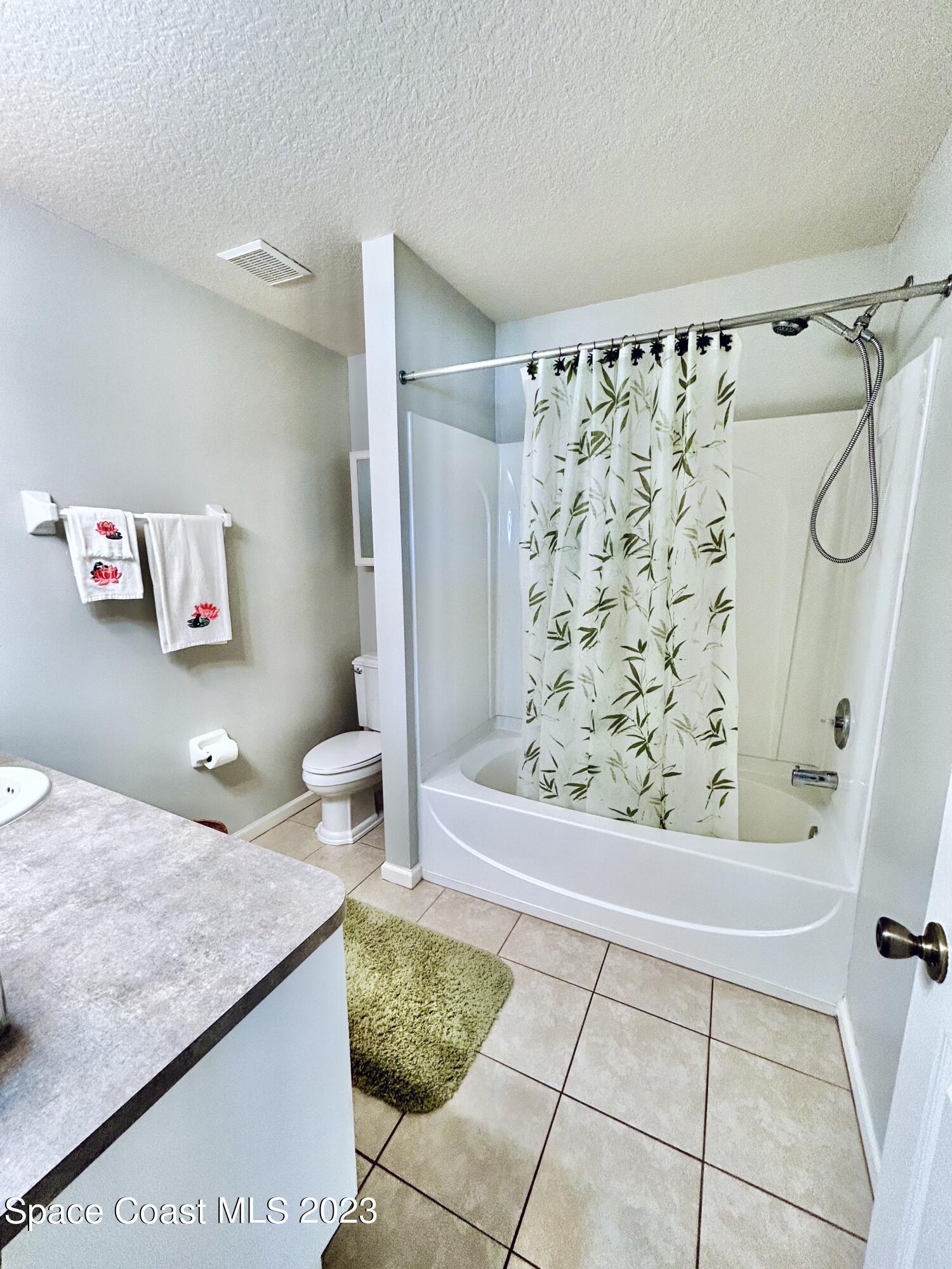 1160 Luminary Circle, Unit 105 Melbourne, FL 32901 - Photo 22 of 35 a bathroom with a granite countertop sink a toilet and shower