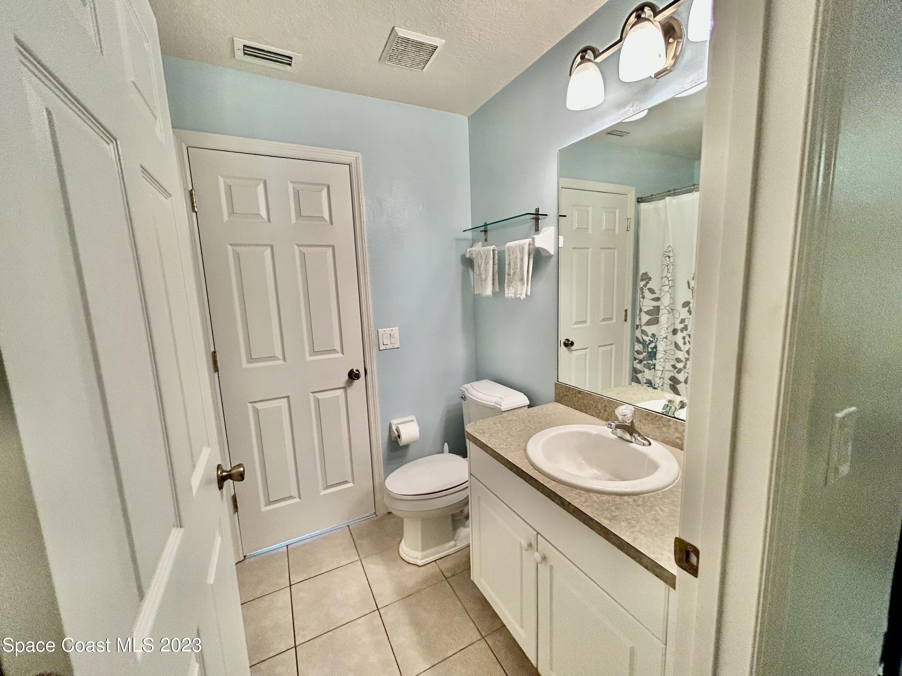 1160 Luminary Circle, Unit 105 Melbourne, FL 32901 - Photo 26 of 35 a bathroom with a sink a toilet and shower a mirror