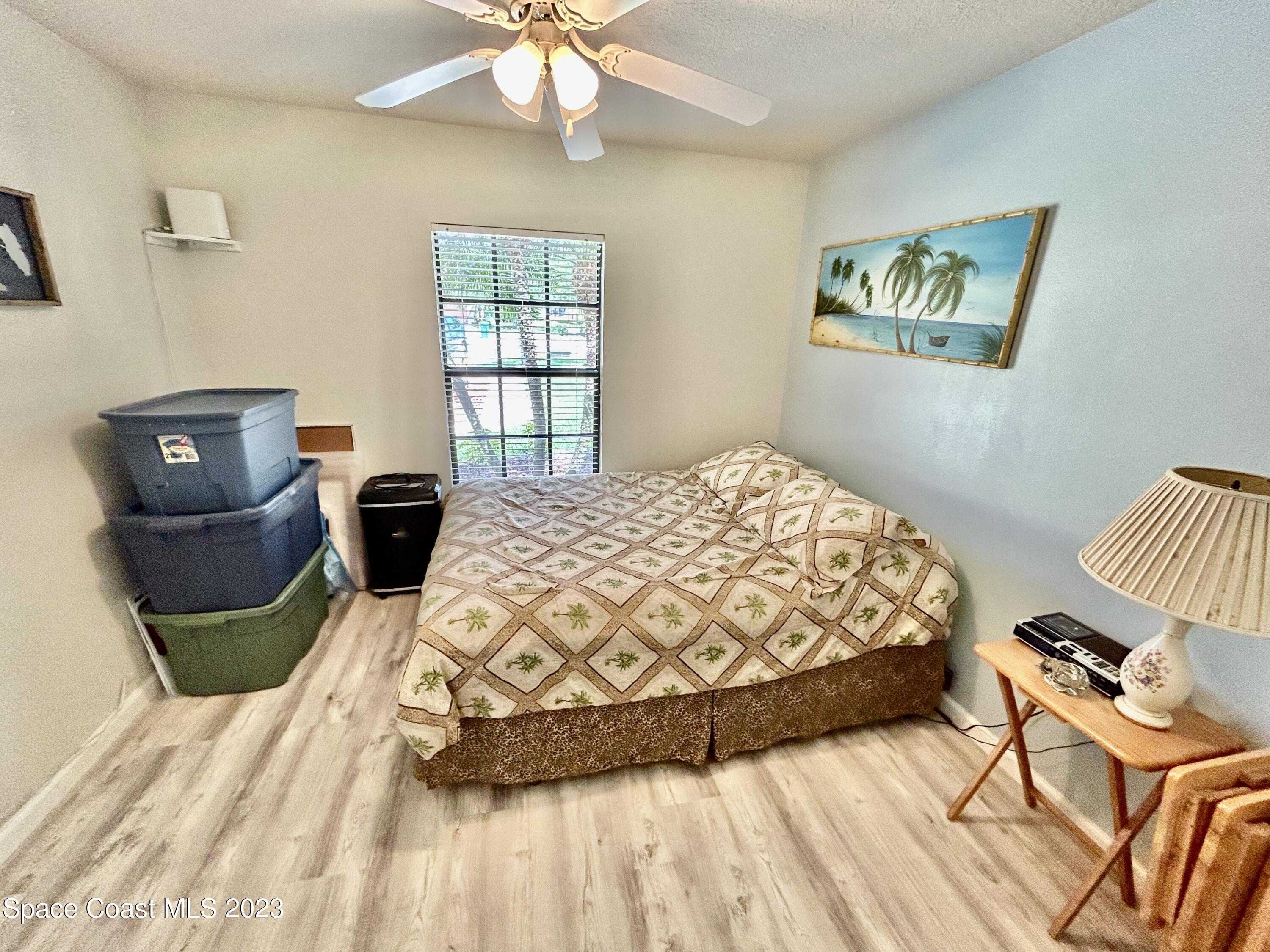 1160 Luminary Circle, Unit 105 Melbourne, FL 32901 - Photo 28 of 35 a bedroom with a bed and wooden floor