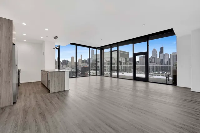 a view of an empty room with wooden floor and a floor to ceiling window
