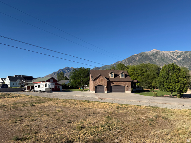 126 Burraston Road, Unit 2 Mona, UT 84645 - Photo 7 of 7 Brick exterior with dormer windows, a two-car garage, and a covered porch