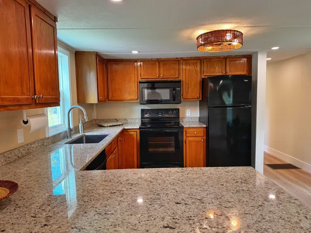 a kitchen with granite countertop a refrigerator and a sink
