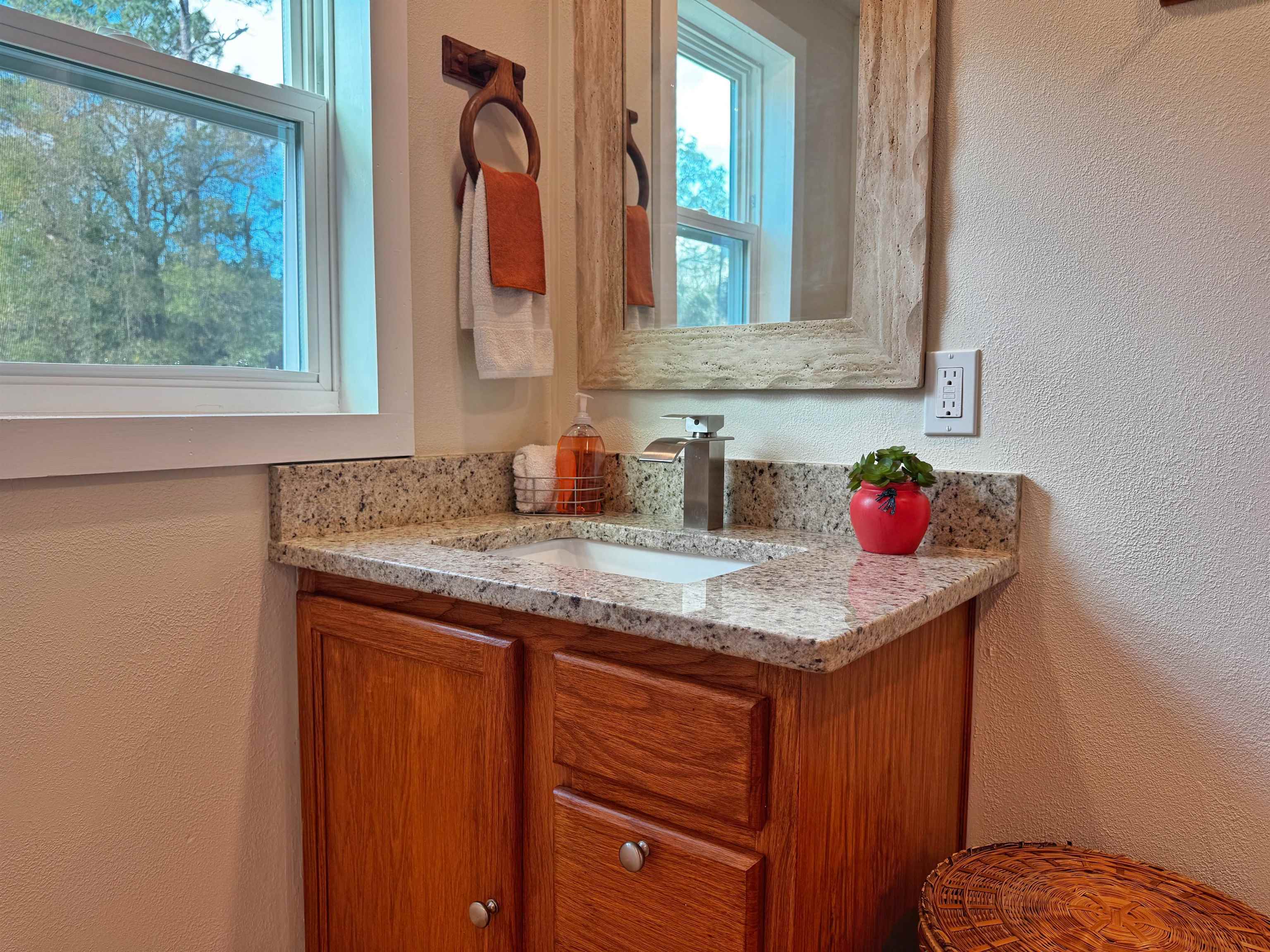 4062 Quail Drive St. Augustine, FL 32084 - Photo 31 of 39 a bathroom with a granite countertop sink and a mirror