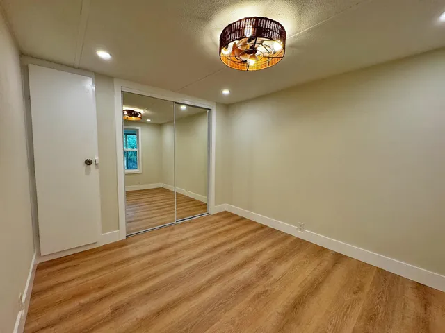 an empty room with a wooden floor and windows