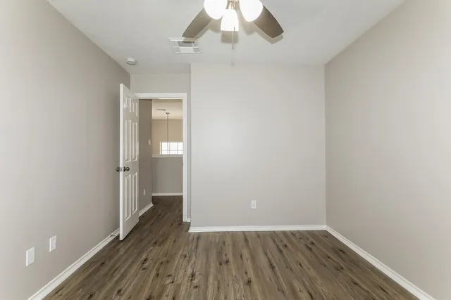 a view of an empty room with wooden floor