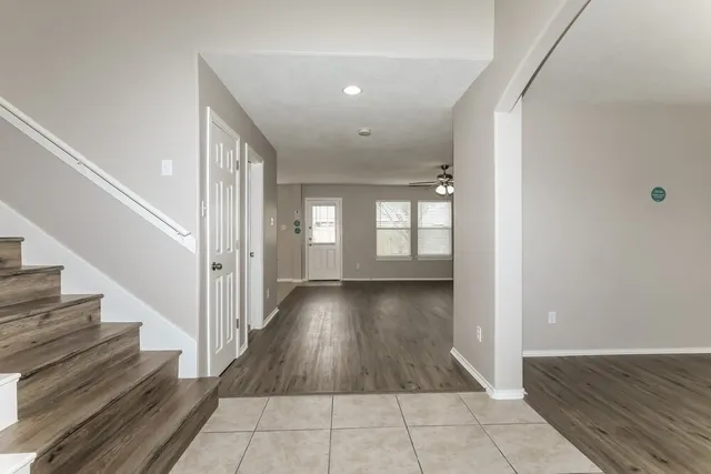 a view of an empty room with a window and wooden floor
