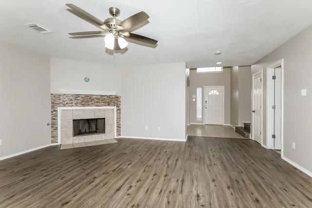 a view of an empty room with a window and wooden floor