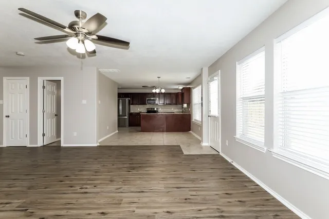 a view of a room with wooden floor exposed radiator and a window