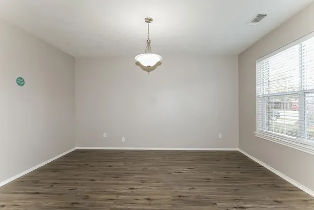 a view of a hallway with wooden floor and entryway