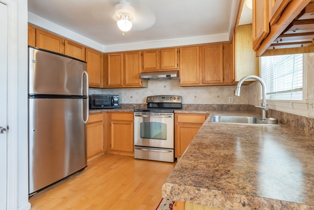 3 East Ridge Road, Unit 3 Merrimack, NH 03054 - Photo 8 of 17 a kitchen with white cabinets and white appliances