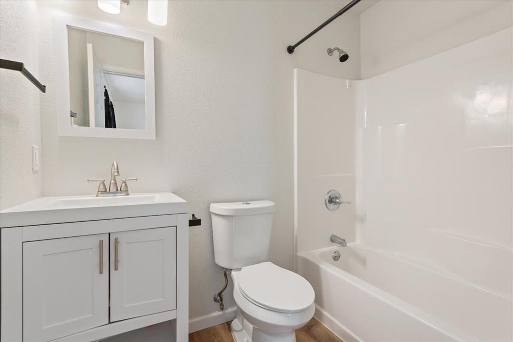 3109 North 20th Street Waco, TX 76708 - Photo 17 of 24 Bathroom featuring a white vanity with brushed nickel hardware, an integrated sink, and a framed mirror