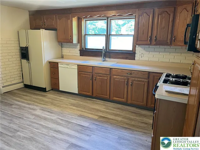 a kitchen with a refrigerator sink and cabinets