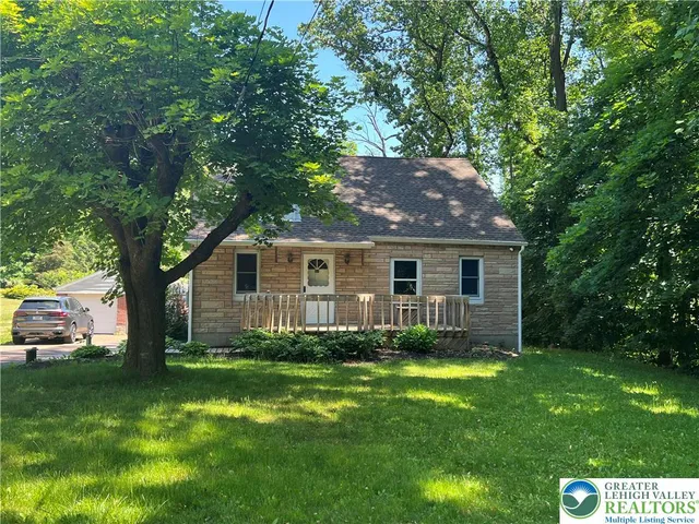 a view of a yard in front of a house with large trees