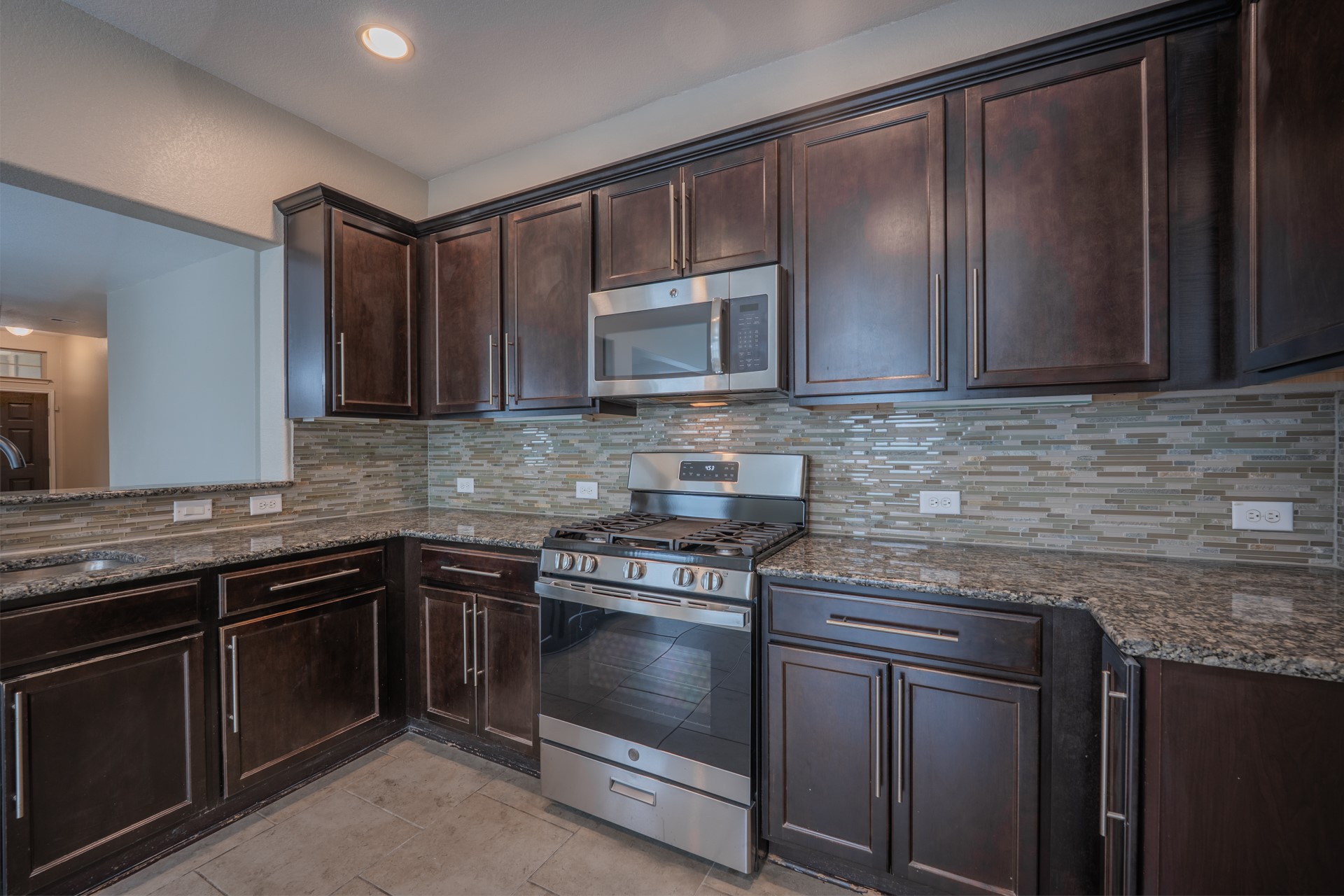 624 Joppa Road Leander, TX 78641 - Photo 11 of 36 a kitchen with stainless steel appliances granite countertop wooden cabinets and a stove top oven
