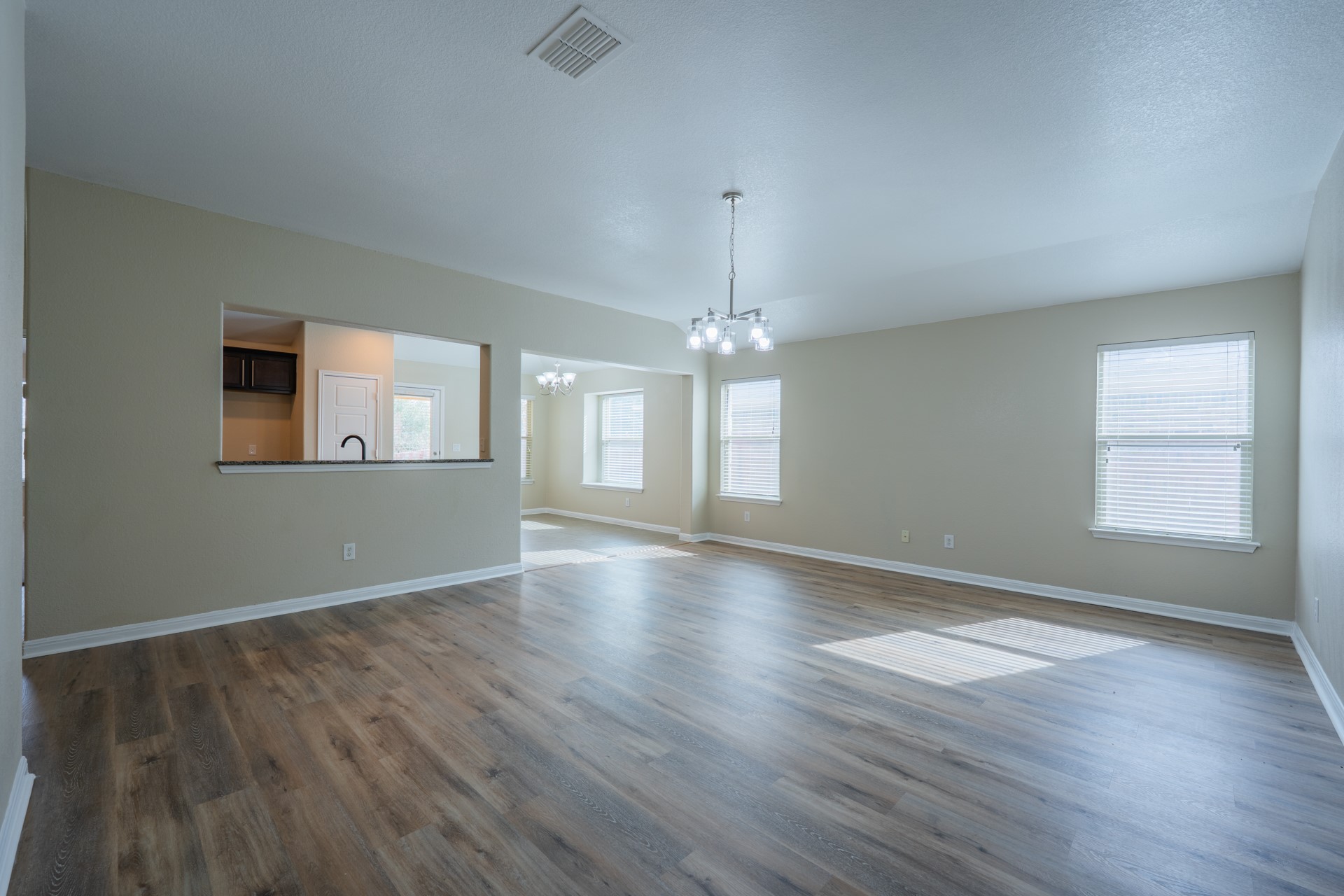 624 Joppa Road Leander, TX 78641 - Photo 5 of 36 an empty room with wooden floor chandelier and glass door