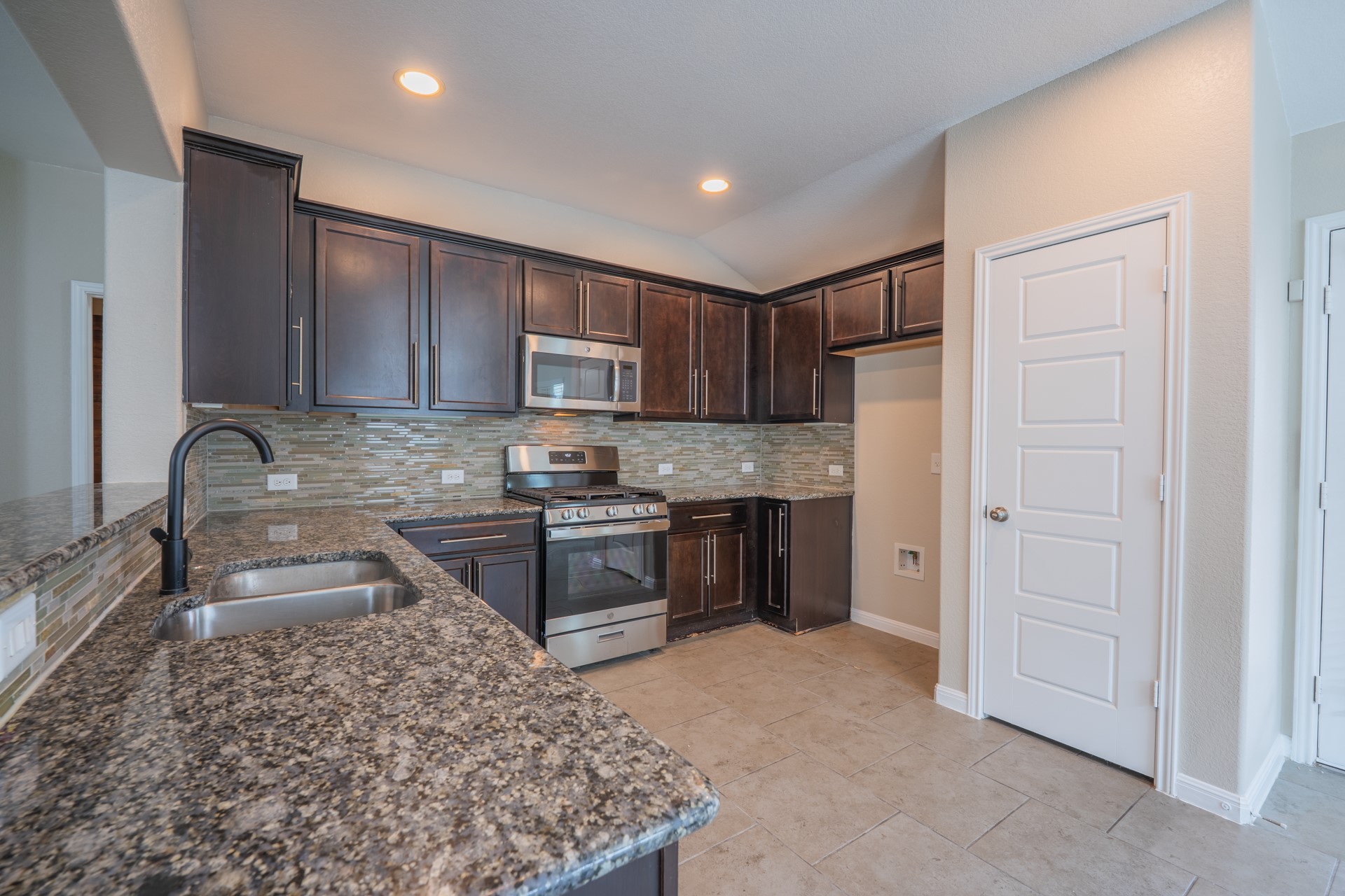 624 Joppa Road Leander, TX 78641 - Photo 8 of 36 a kitchen with stainless steel appliances granite countertop a sink stove and refrigerator