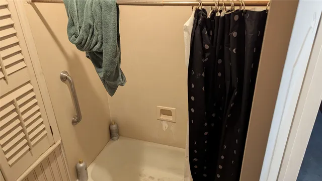 a bathroom with a shower and a mirror