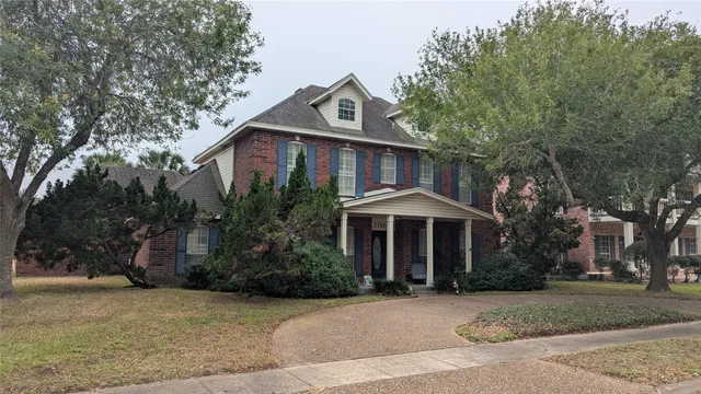 a front view of a house with yard and trees