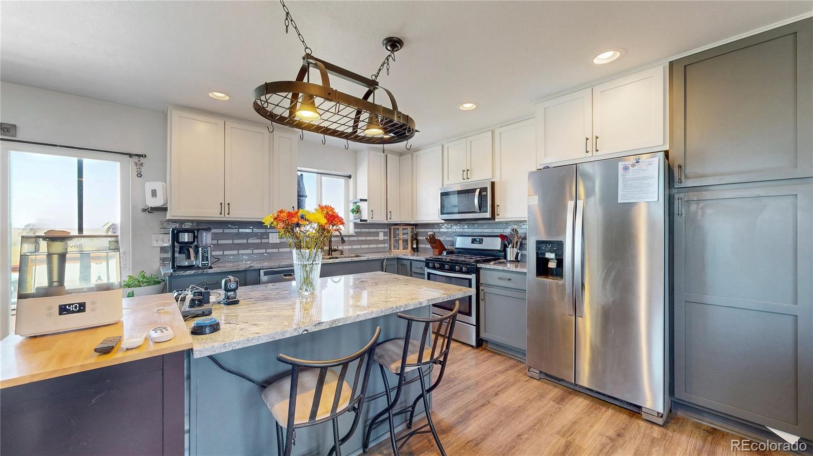 40291 Gold Nugget Road Deer Trail, CO 80105 - Photo 12 of 47 a kitchen with stainless steel appliances granite countertop a sink a stove a refrigerator cabinets and dining table