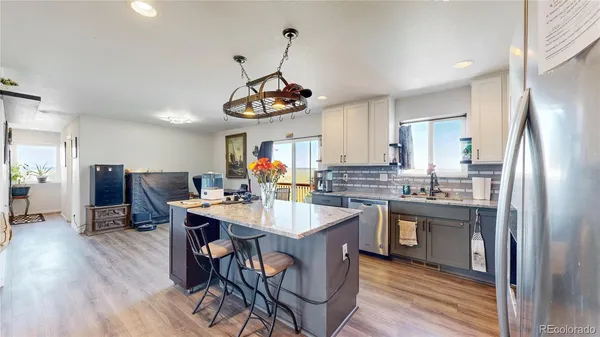 a kitchen with stainless steel appliances granite countertop a sink dishwasher a stove a refrigerator with island and chairs