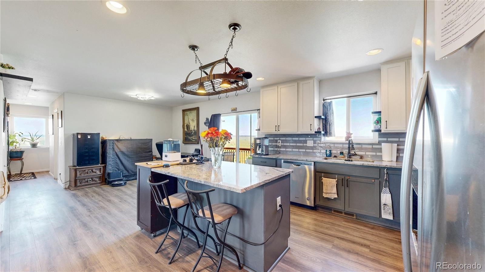 40291 Gold Nugget Road Deer Trail, CO 80105 - Photo 13 of 47 a kitchen with stainless steel appliances granite countertop a sink dishwasher a stove a refrigerator with island and chairs