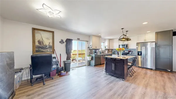 a kitchen with stainless steel appliances kitchen island granite countertop wooden floors and wooden cabinets