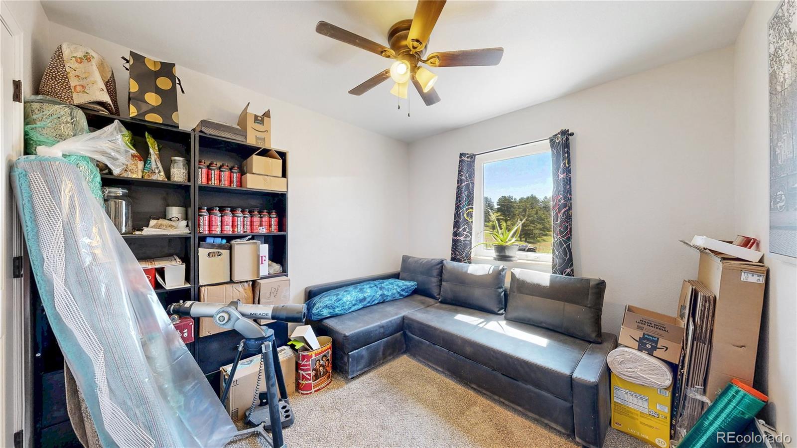 40291 Gold Nugget Road Deer Trail, CO 80105 - Photo 16 of 47 a living room with lots of furniture and a book shelf