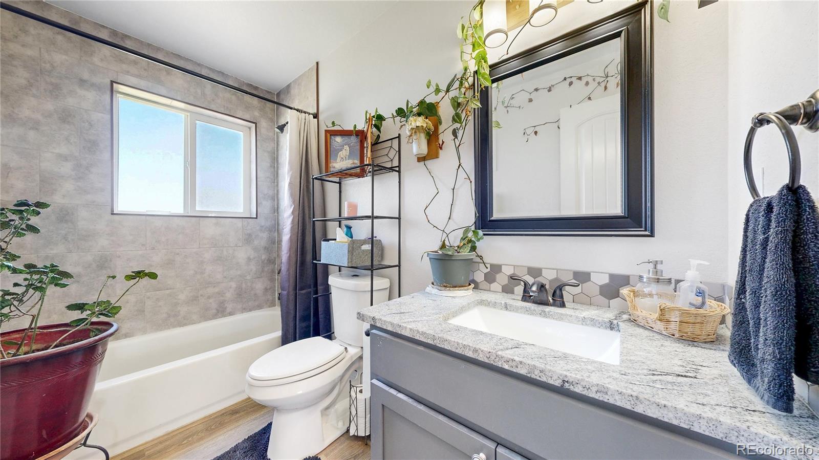 40291 Gold Nugget Road Deer Trail, CO 80105 - Photo 17 of 47 a bathroom with a granite countertop sink toilet and shower