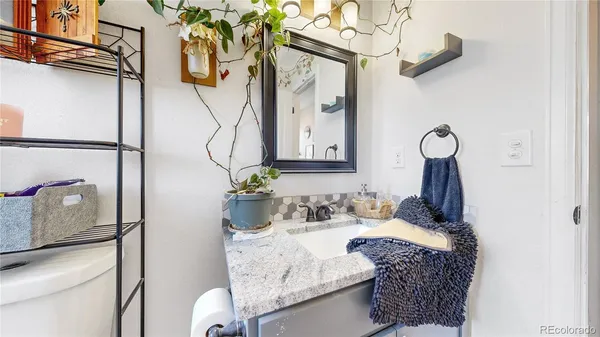 a bathroom with a granite countertop sink a toilet and mirror