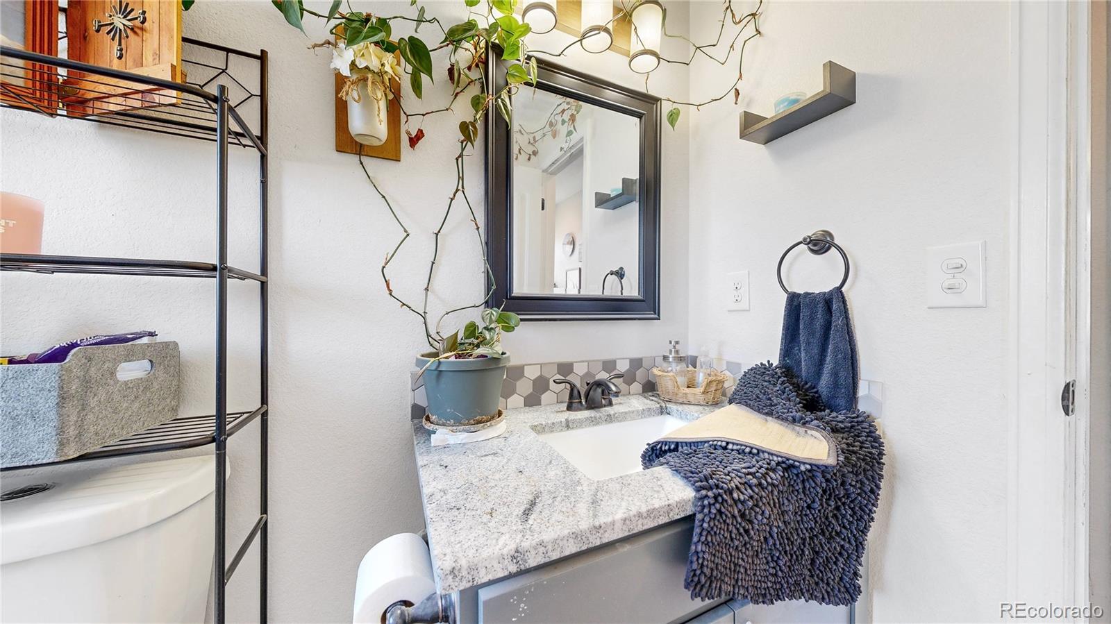 40291 Gold Nugget Road Deer Trail, CO 80105 - Photo 18 of 47 a bathroom with a granite countertop sink a toilet and mirror