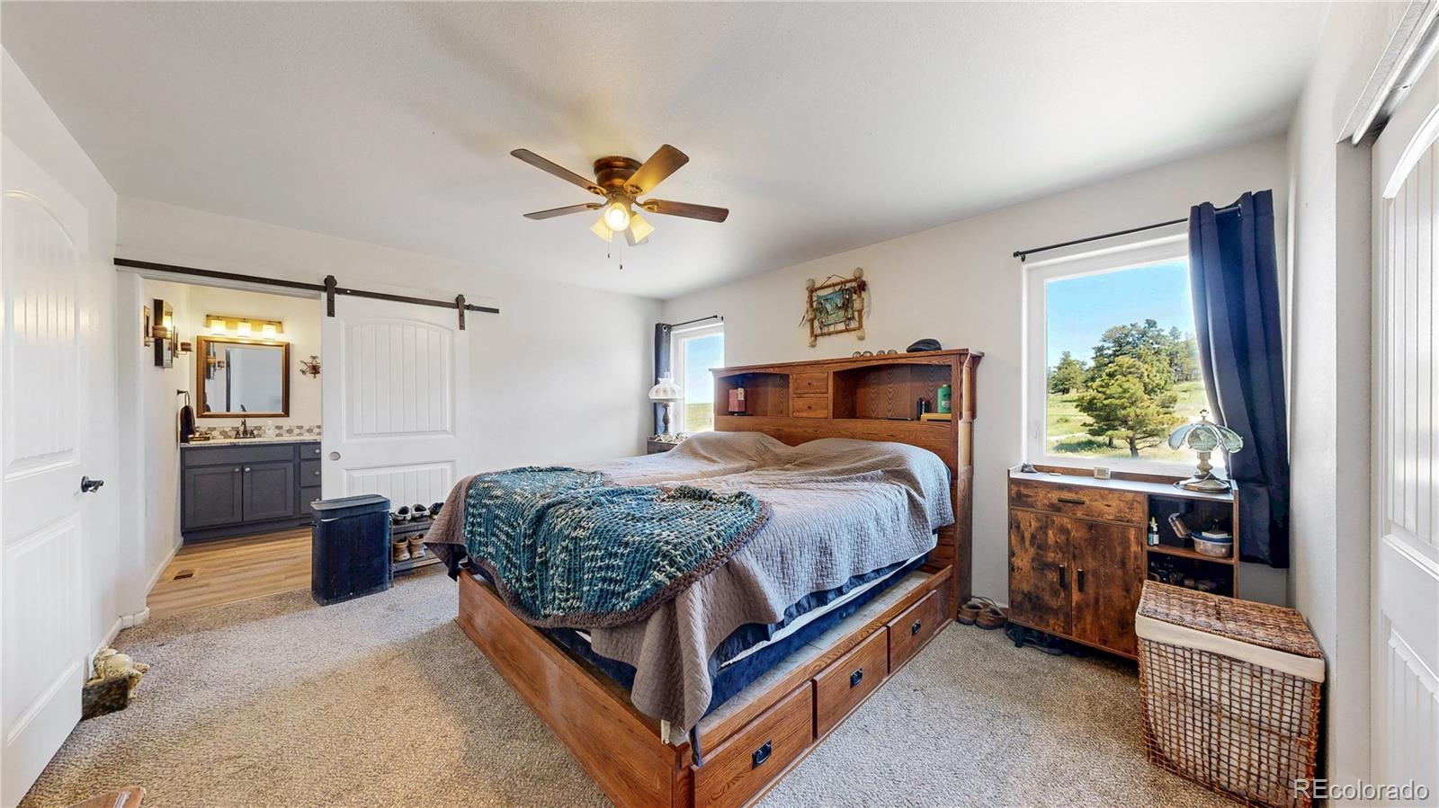40291 Gold Nugget Road Deer Trail, CO 80105 - Photo 21 of 47 a bedroom with a bed and a chandelier