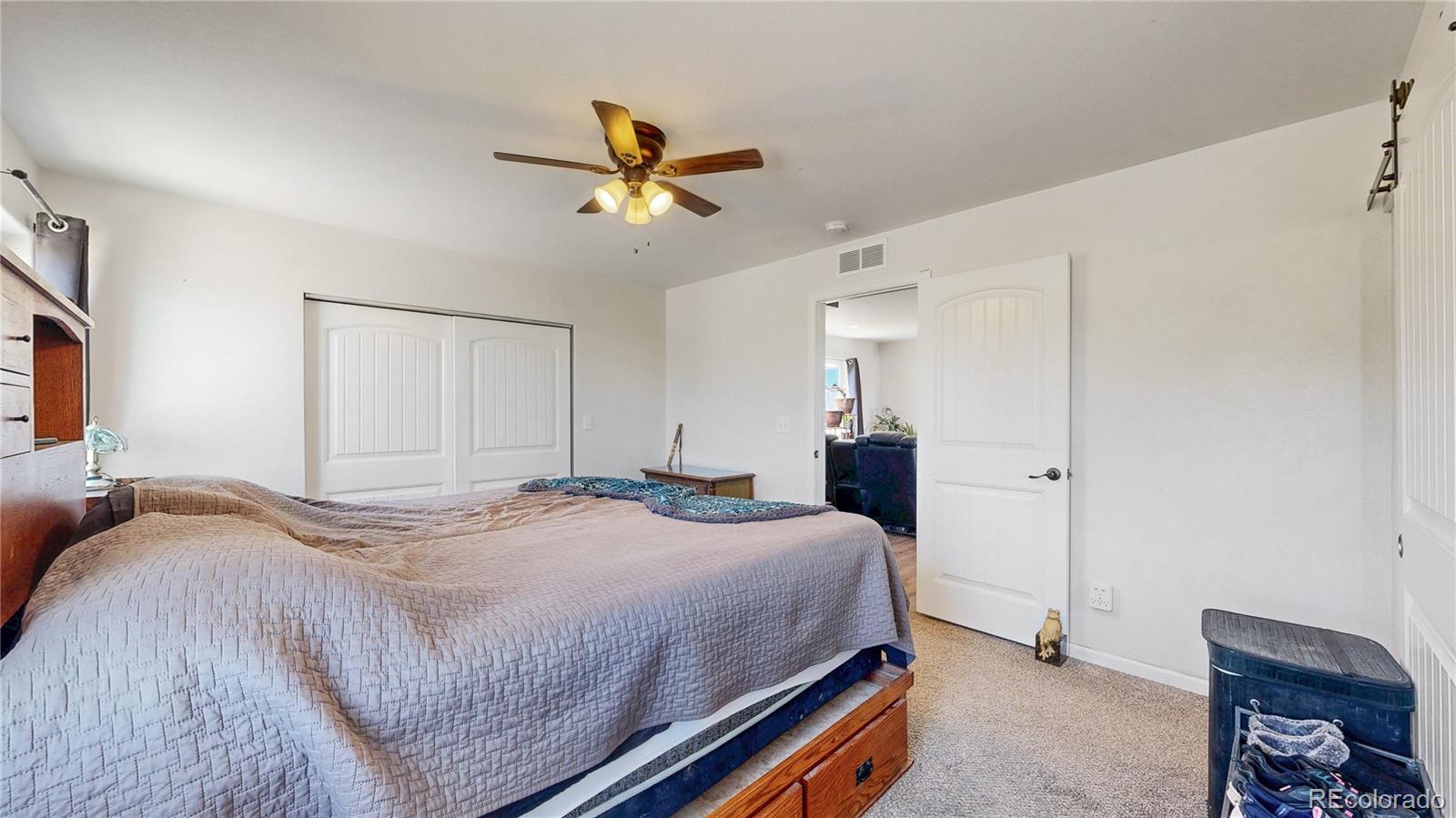 40291 Gold Nugget Road Deer Trail, CO 80105 - Photo 23 of 47 a bedroom with a bed and a chandelier