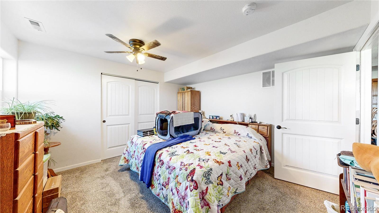 40291 Gold Nugget Road Deer Trail, CO 80105 - Photo 31 of 47 a bedroom with bed and a chandelier