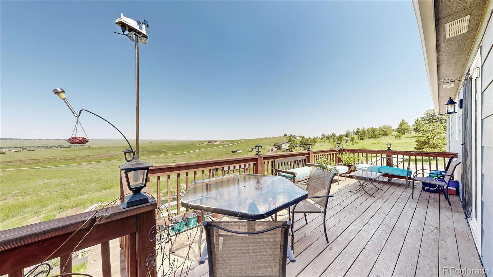 40291 Gold Nugget Road Deer Trail, CO 80105 - Photo 38 of 47 a view of a balcony with wooden floor and outdoor seating