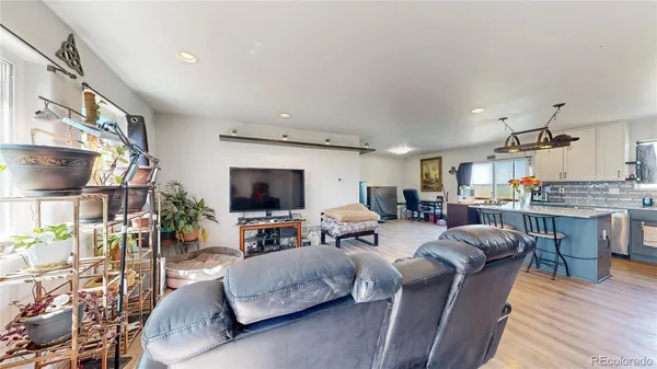 a living room with furniture a flat screen tv and kitchen view