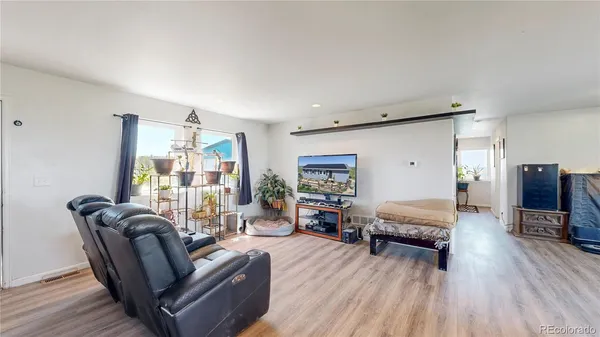 a living room with furniture and wooden floor