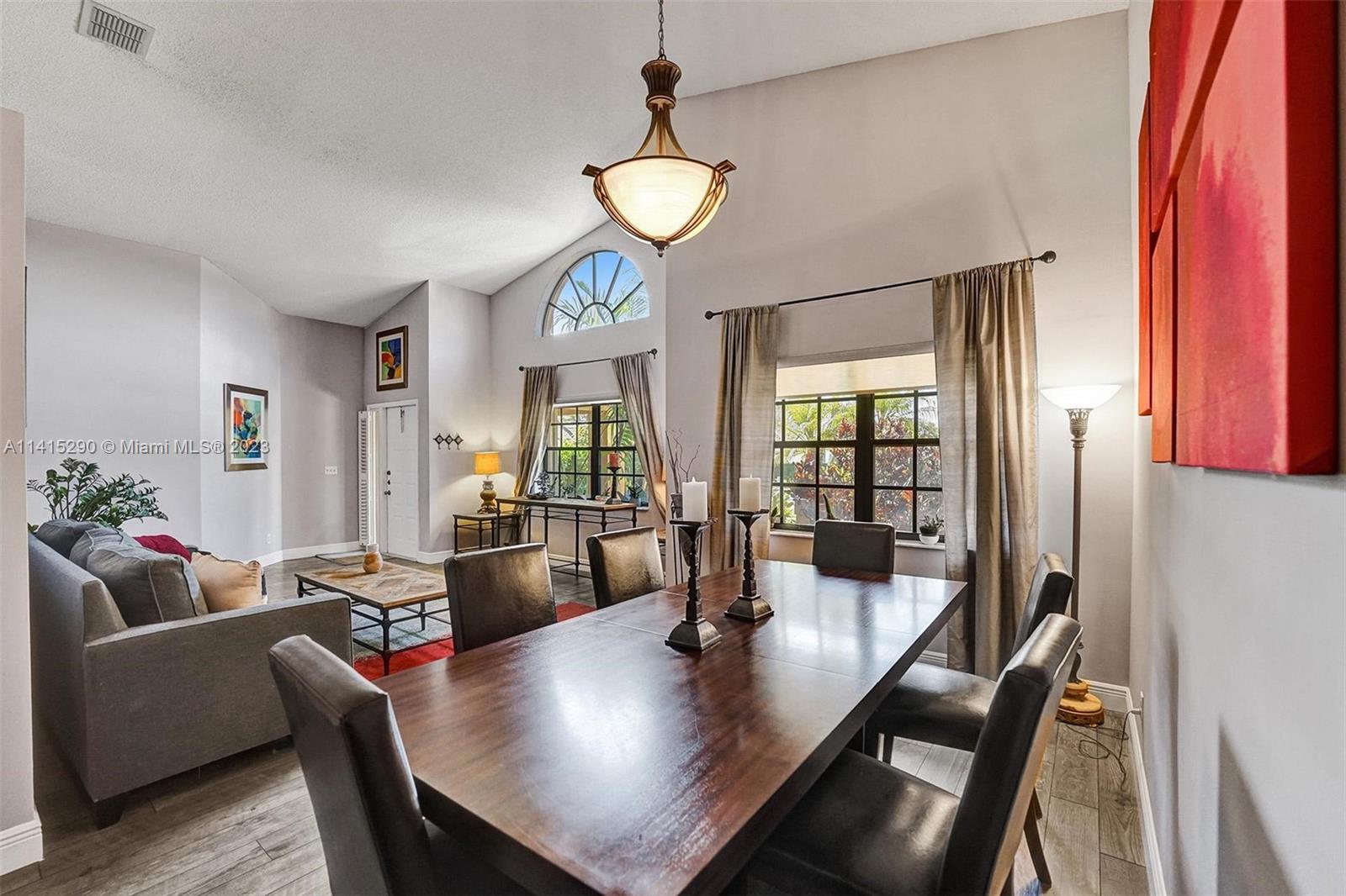 9641 Ridgeside Court Davie, FL 33328 - Photo 17 of 78 a view of a dining room with furniture wooden floor and a chandelier