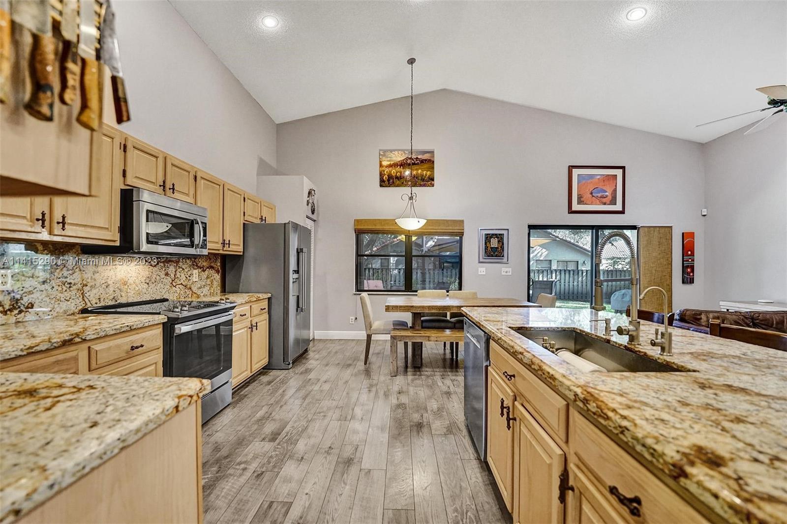 9641 Ridgeside Court Davie, FL 33328 - Photo 29 of 78 a kitchen with stainless steel appliances granite countertop a sink stove and refrigerator