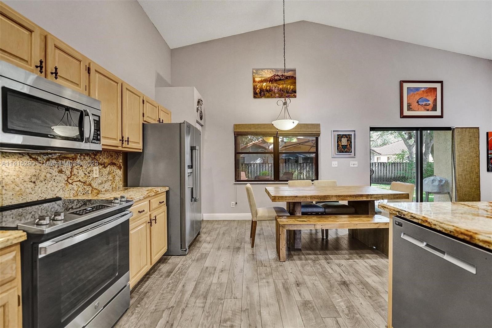 9641 Ridgeside Court Davie, FL 33328 - Photo 30 of 78 a kitchen with stainless steel appliances granite countertop a stove and a wooden floors