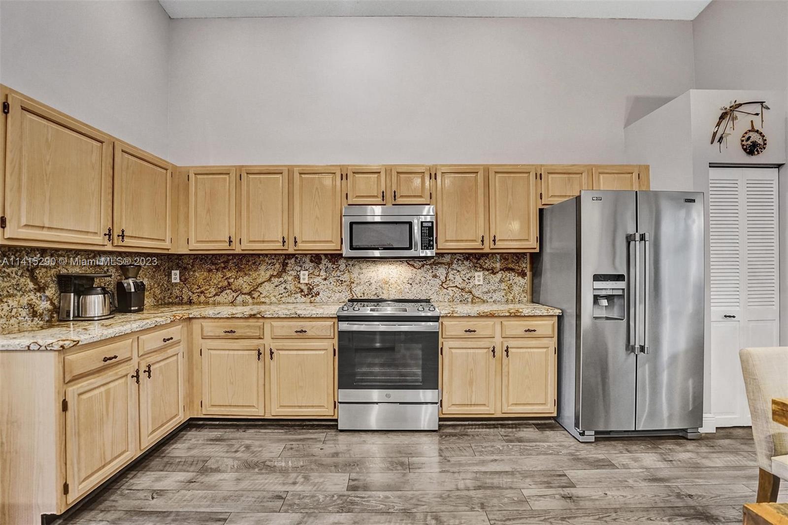 9641 Ridgeside Court Davie, FL 33328 - Photo 32 of 78 a kitchen with stainless steel appliances granite countertop a stove a sink and a refrigerator