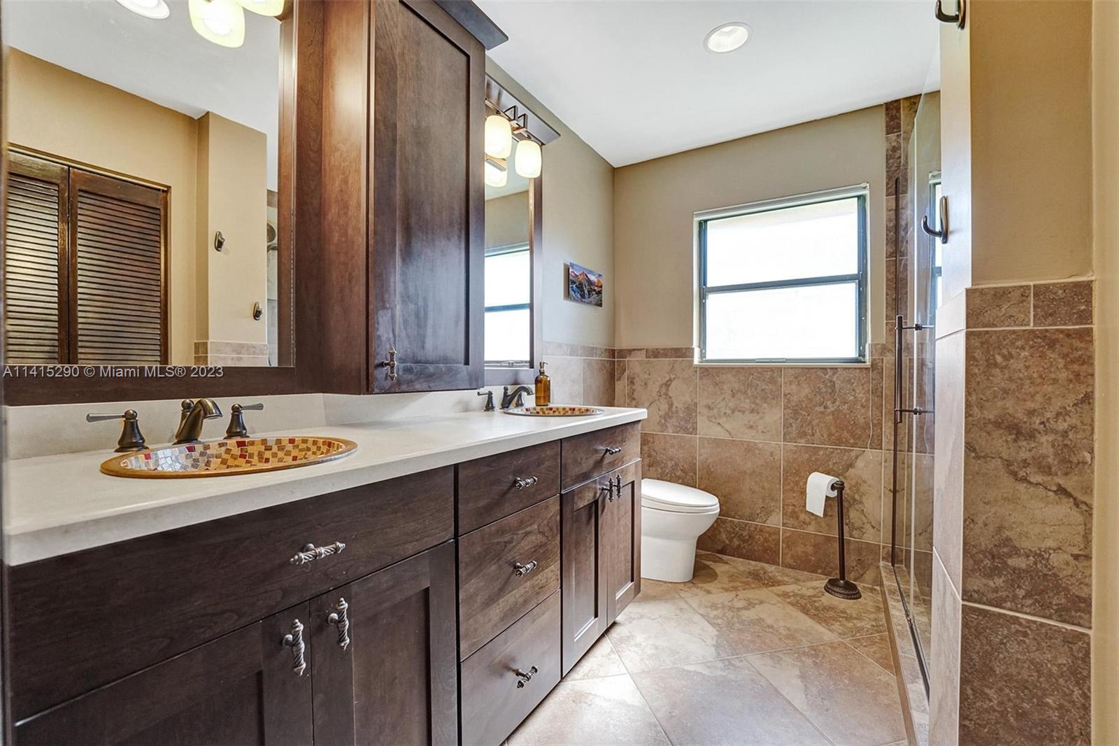 9641 Ridgeside Court Davie, FL 33328 - Photo 38 of 78 a bathroom with a double vanity sink toilet and two mirror