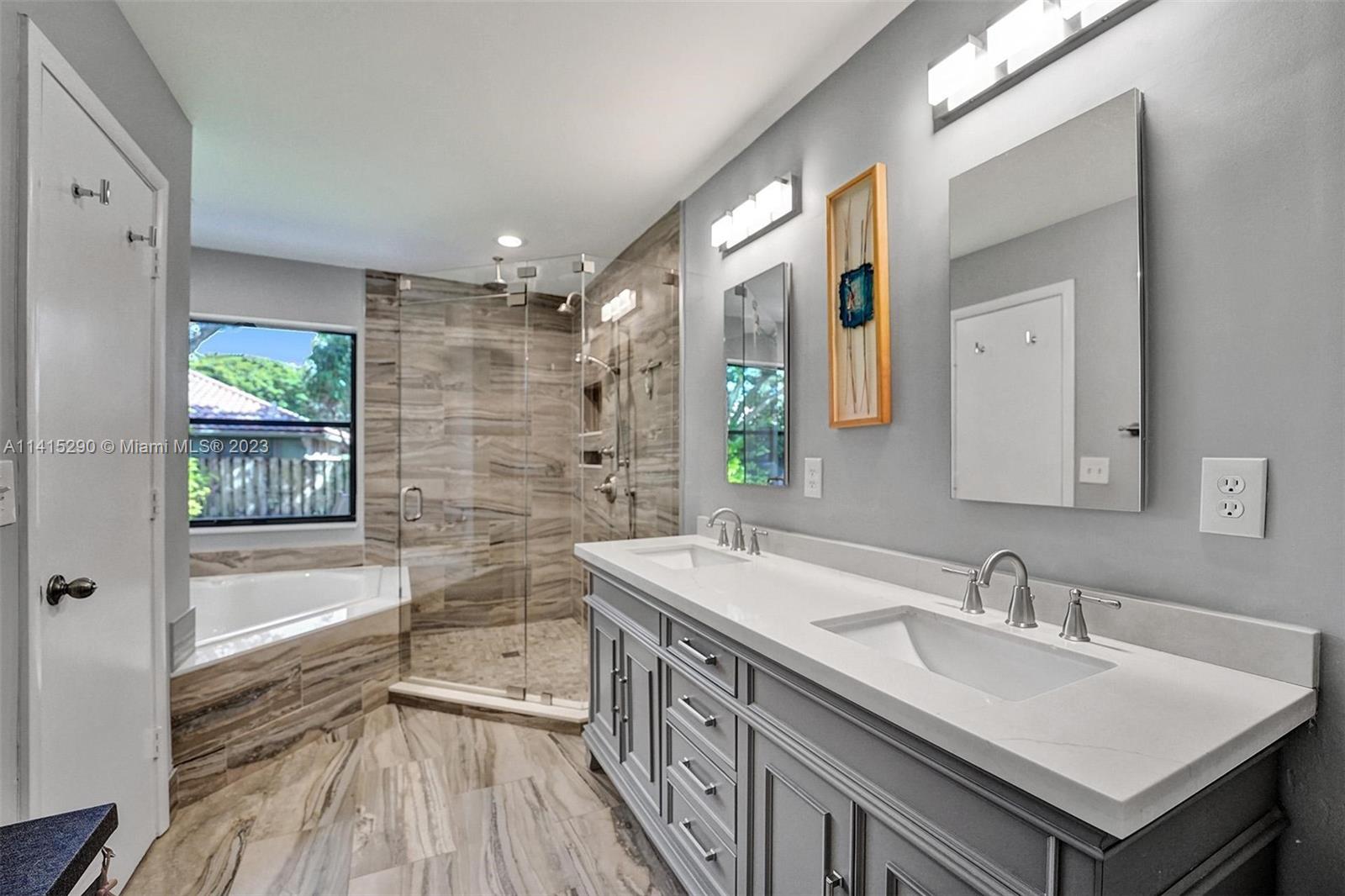 9641 Ridgeside Court Davie, FL 33328 - Photo 48 of 78 a bathroom with a sink a large mirror and a bathtub