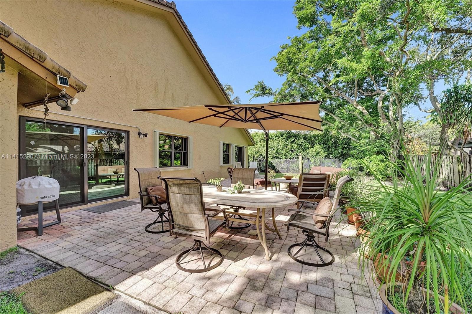 9641 Ridgeside Court Davie, FL 33328 - Photo 63 of 78 a view of a patio with table and chairs under an umbrella
