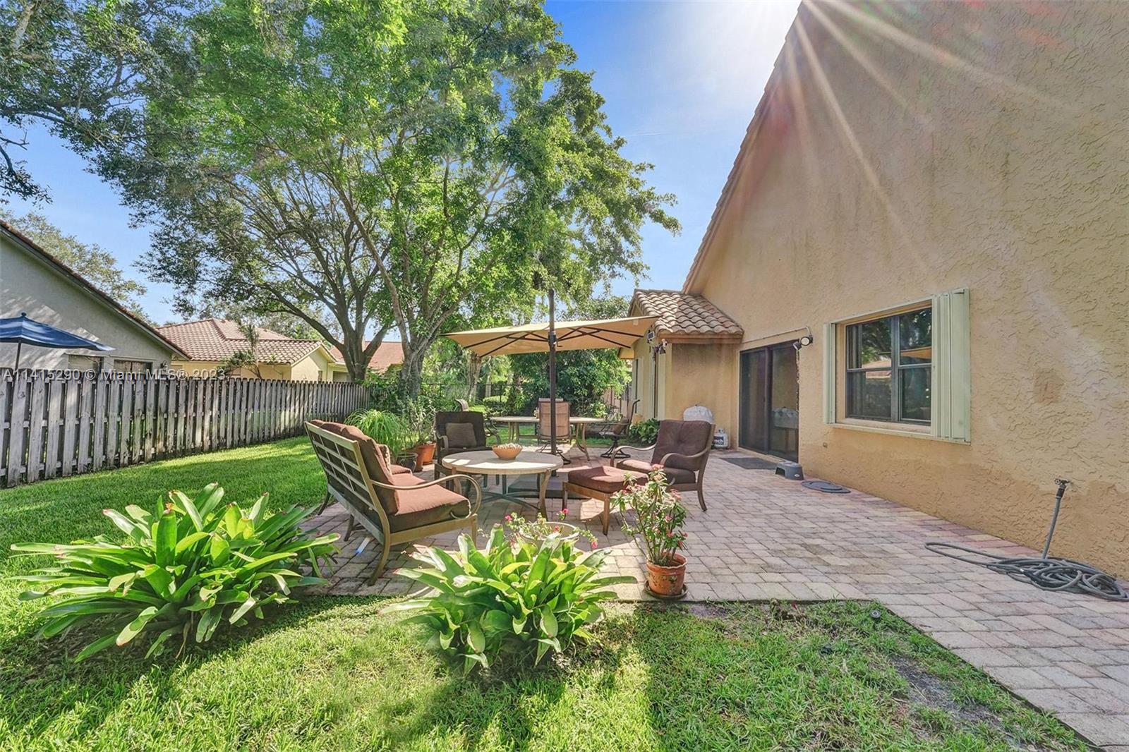 9641 Ridgeside Court Davie, FL 33328 - Photo 65 of 78 a view of a patio with table and chairs potted plants and large tree